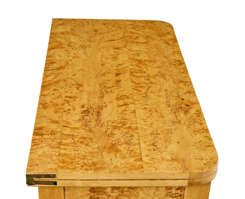 A 19th-century Swedish tea table constructed from warm burr birch veneer featuring slender tapered legs and a folding rectangular top. View III