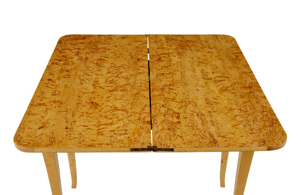 A 19th-century Swedish tea table constructed from warm burr birch veneer featuring slender tapered legs and a folding rectangular top. View V