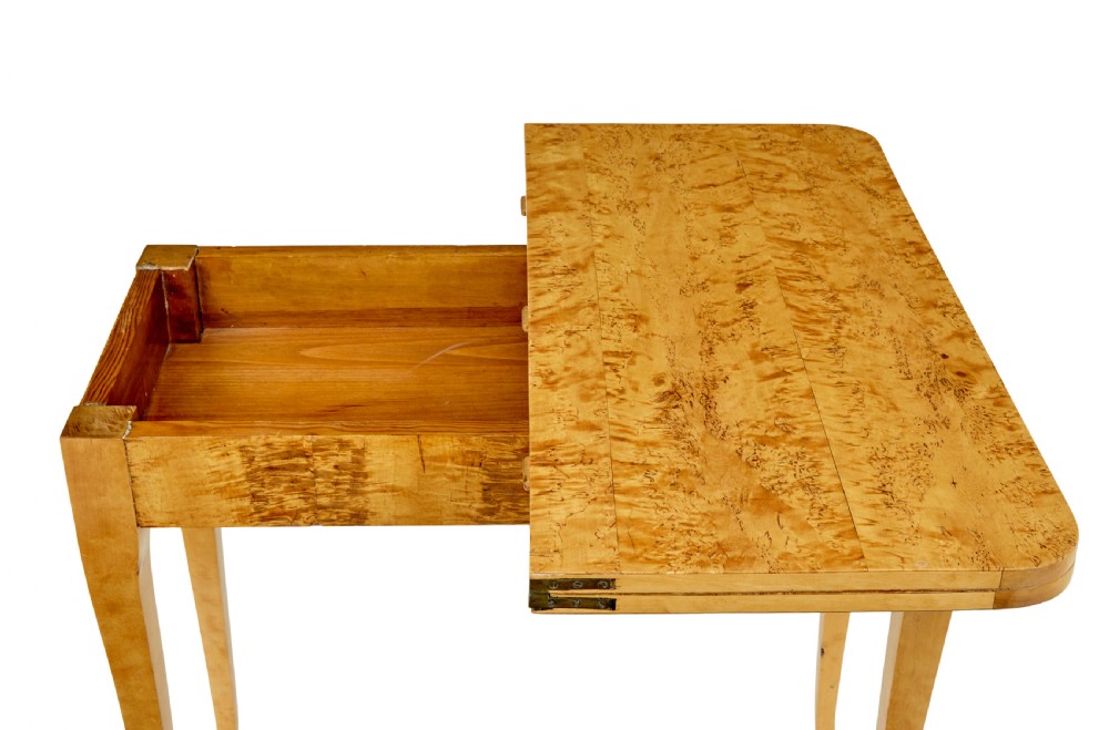 A 19th-century Swedish tea table constructed from warm burr birch veneer featuring slender tapered legs and a folding rectangular top. View VI