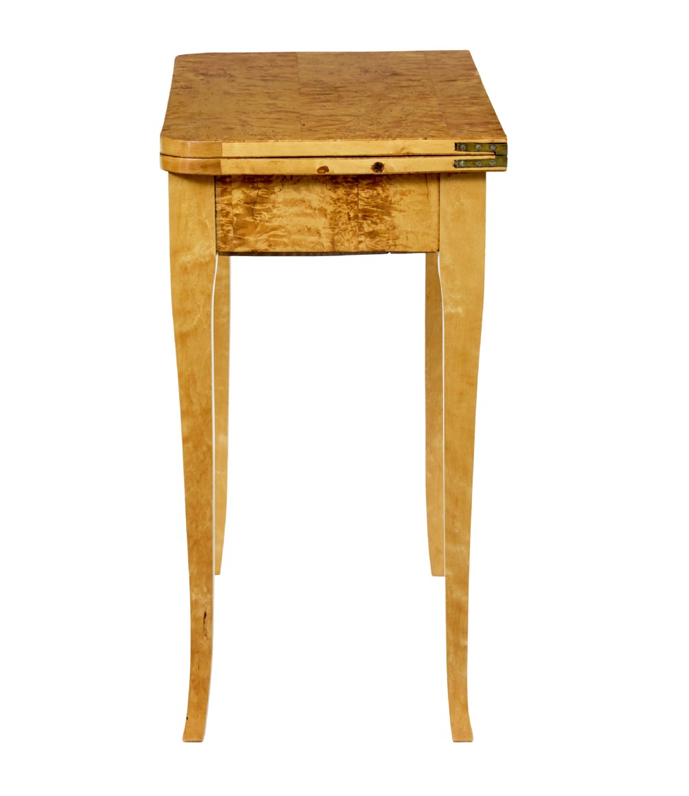A 19th-century Swedish tea table constructed from warm burr birch veneer featuring slender tapered legs and a folding rectangular top. View VIII