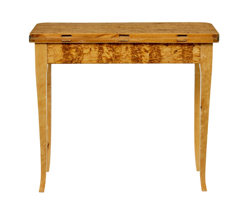A 19th-century Swedish tea table constructed from warm burr birch veneer featuring slender tapered legs and a folding rectangular top. View IX