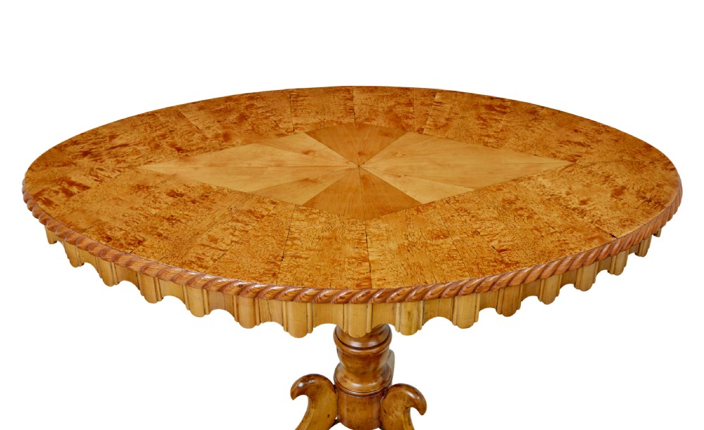 A nineteenth-century oval occasional table crafted from inlaid burr birch with a scalloped apron, turned central pedestal, and four carved scrolled legs. View III