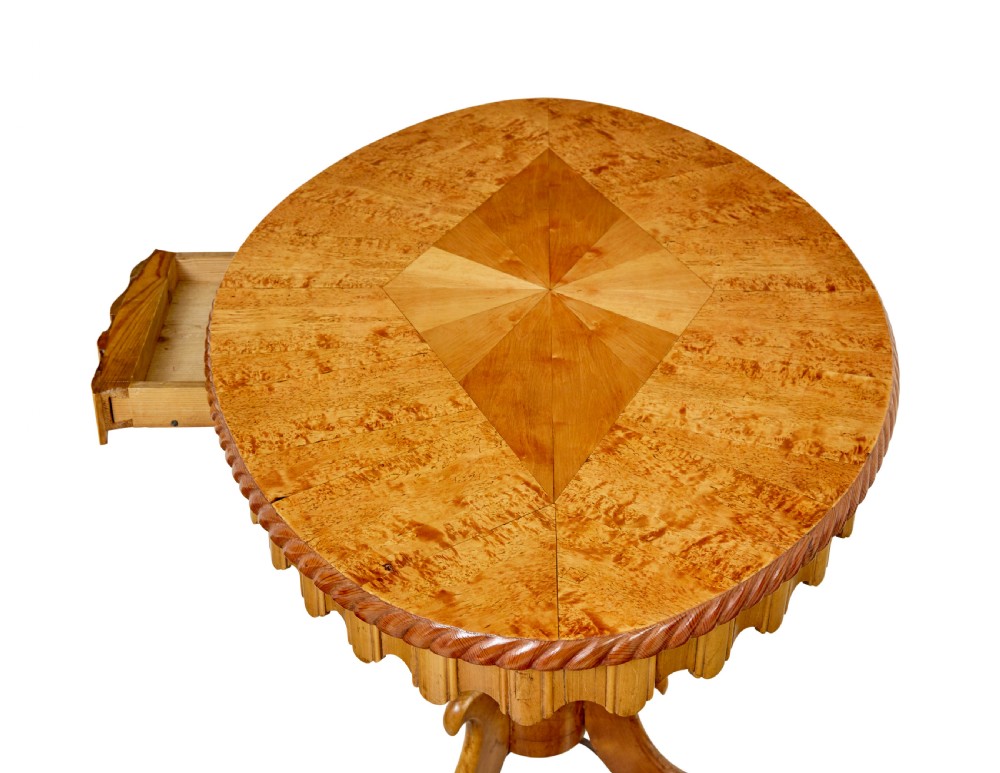 A nineteenth-century oval occasional table crafted from inlaid burr birch with a scalloped apron, turned central pedestal, and four carved scrolled legs. View IV
