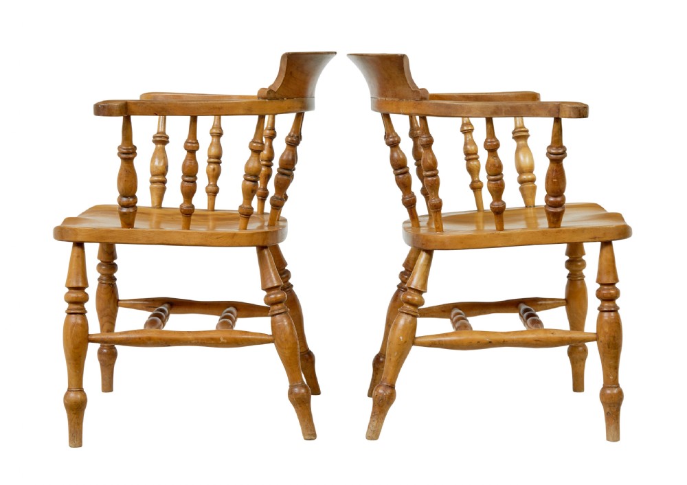 A pair of 19th-century light brown elm elbow chairs featuring curved crest rails, turned spindle backs, shaped saddle seats, and turned legs. View II