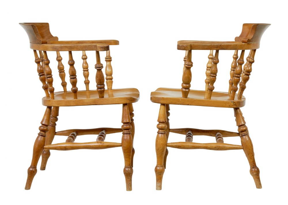 A pair of 19th-century light brown elm elbow chairs featuring curved crest rails, turned spindle backs, shaped saddle seats, and turned legs. View III