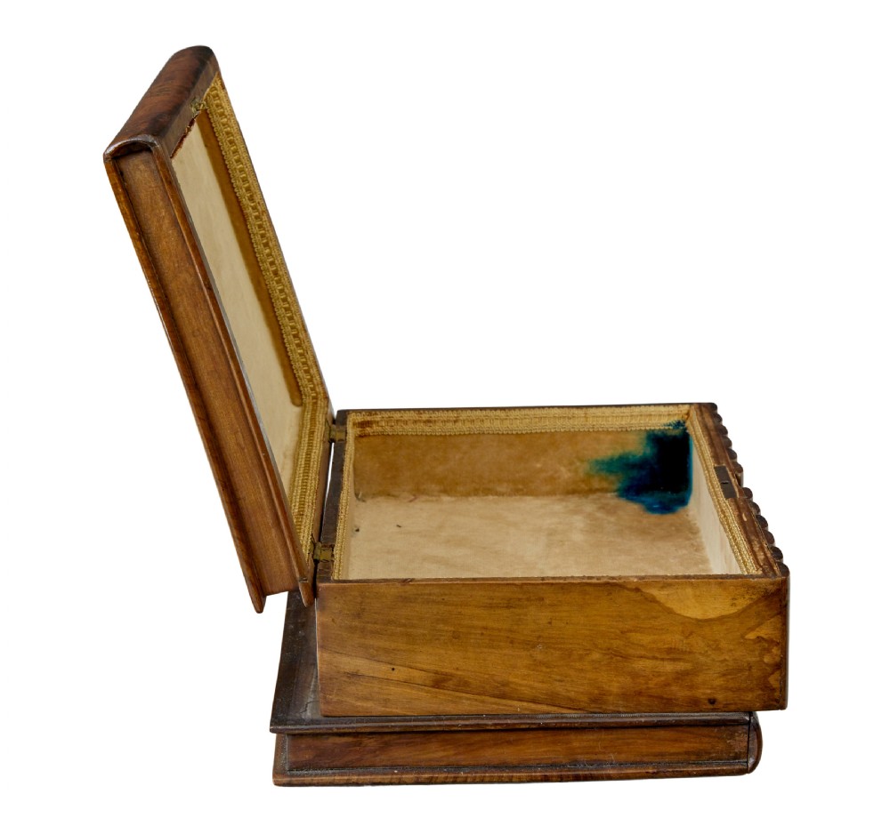 A 19th-century olive wood box crafted in the shape of a stack of books, featuring detailed floral marquetry inlay on the lid and carved book spines on the sides. View III