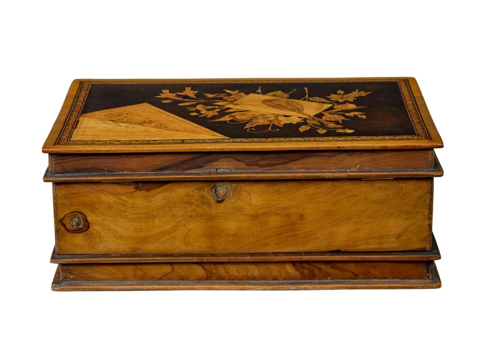 A 19th-century olive wood box crafted in the shape of a stack of books, featuring detailed floral marquetry inlay on the lid and carved book spines on the sides. View IV