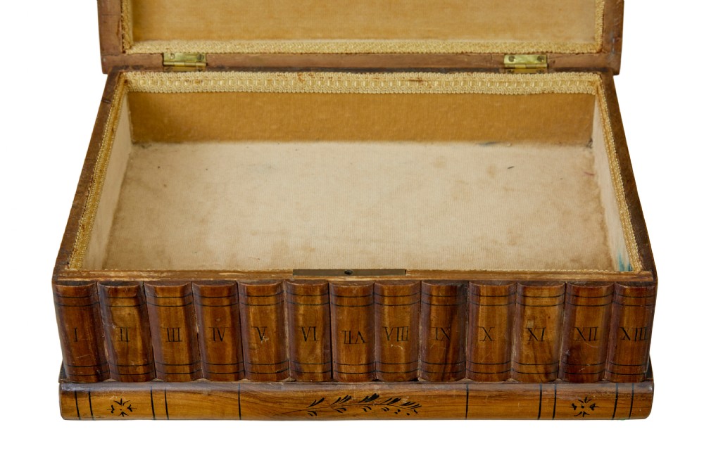 A 19th-century olive wood box crafted in the shape of a stack of books, featuring detailed floral marquetry inlay on the lid and carved book spines on the sides. View VII