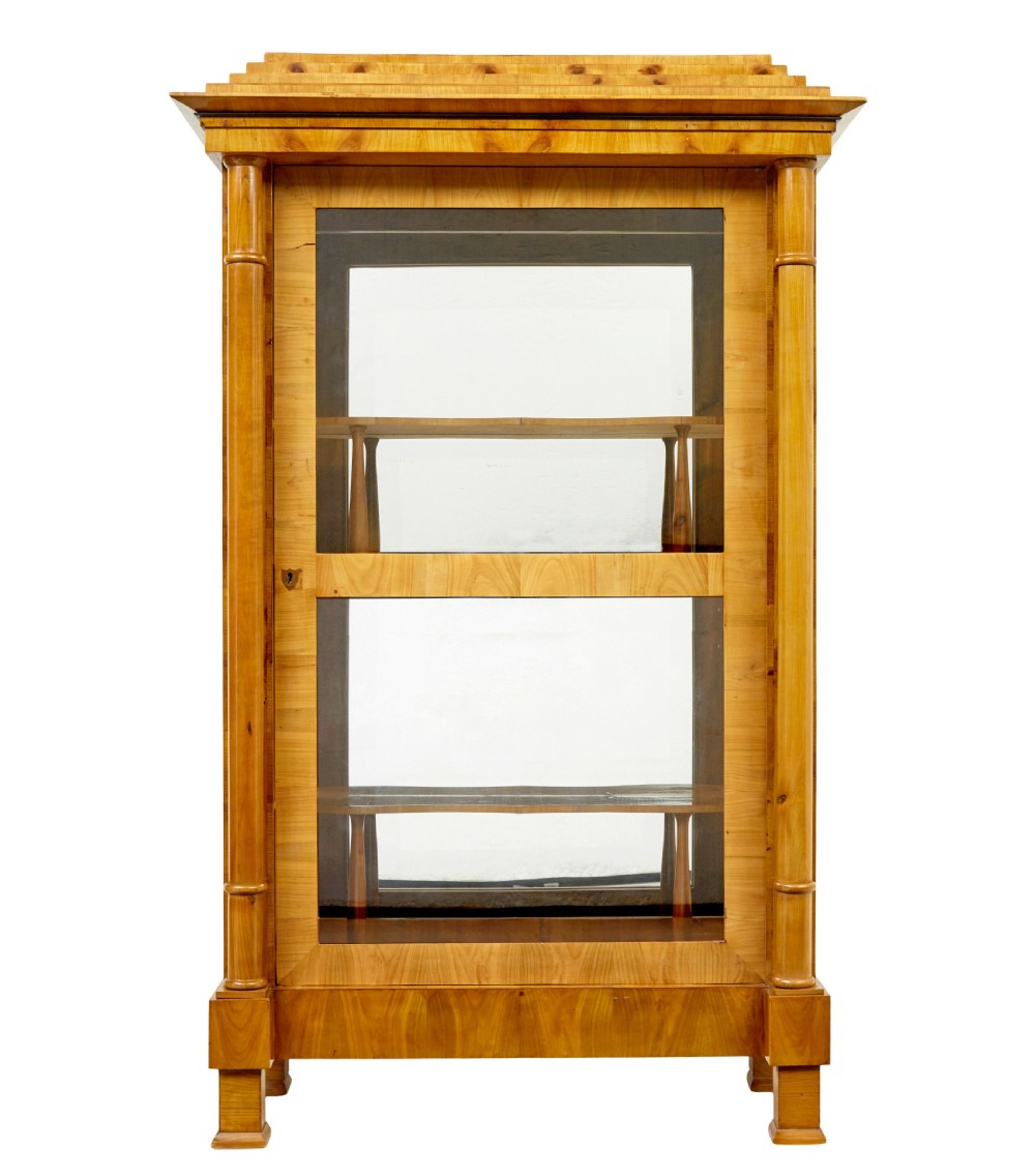 A matching pair of Biedermeier elm display cabinets with glazed doors, side columns, and stepped cornices. View II