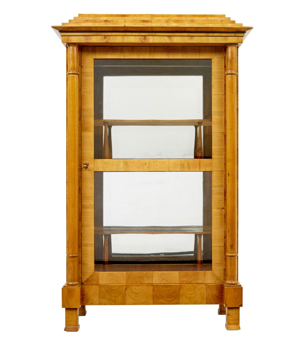 A matching pair of Biedermeier elm display cabinets with glazed doors, side columns, and stepped cornices. View III