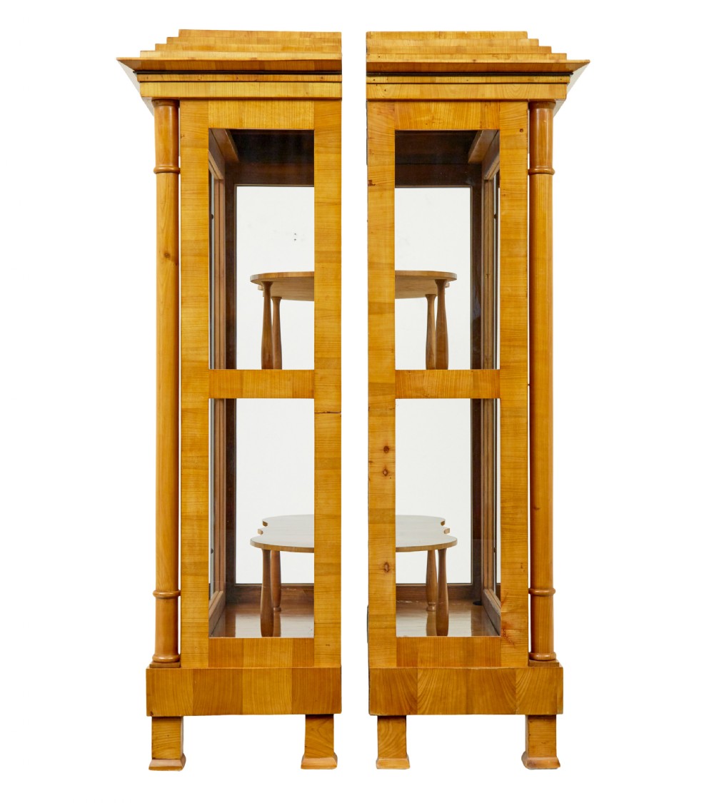 A matching pair of Biedermeier elm display cabinets with glazed doors, side columns, and stepped cornices. View IV