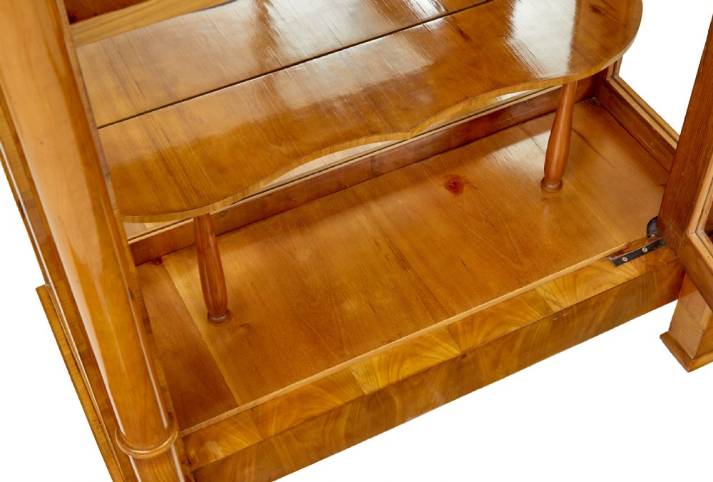 A matching pair of Biedermeier elm display cabinets with glazed doors, side columns, and stepped cornices. View IX