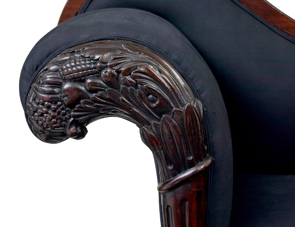 A 19th-century William IV mahogany chaise longue with hand-carved scroll detailing and dark fabric upholstery. View X