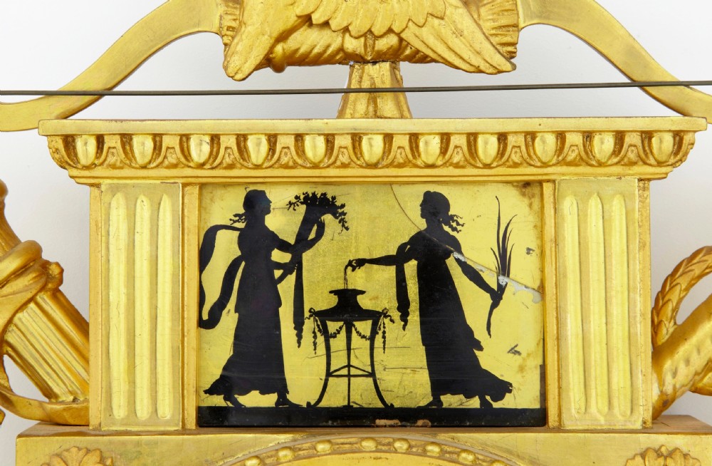 Nineteenth-century Swedish giltwood wall clock adorned with classical silhouettes on eglomise glass panels, carved urns, swags, and twin crested doves. View III