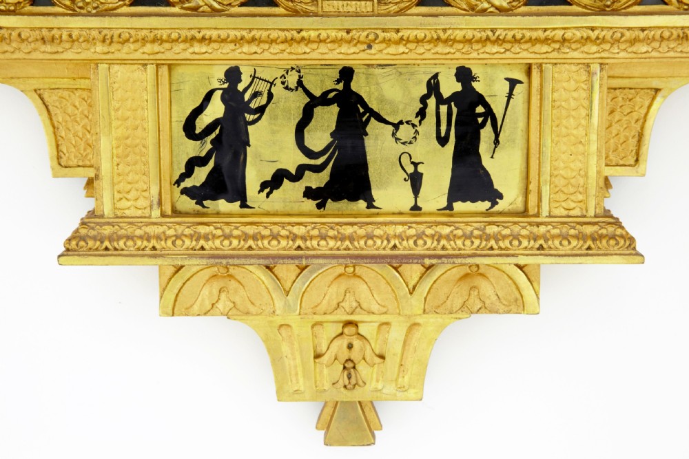 Nineteenth-century Swedish giltwood wall clock adorned with classical silhouettes on eglomise glass panels, carved urns, swags, and twin crested doves. View VII