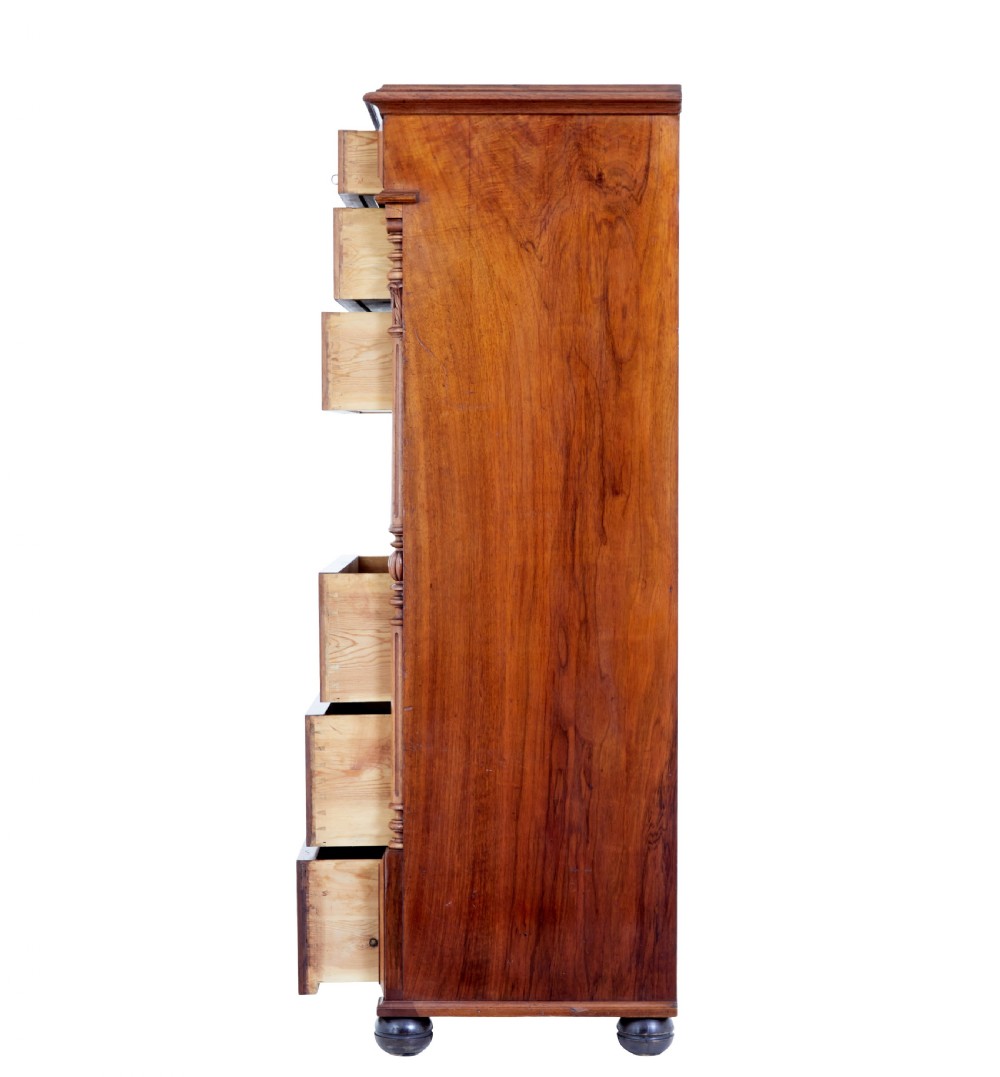 A tall 19th-century burr walnut secretaire chest of drawers featuring bookmatched veneer drawer fronts, fluted side columns, and ornate metal escutcheons. View V