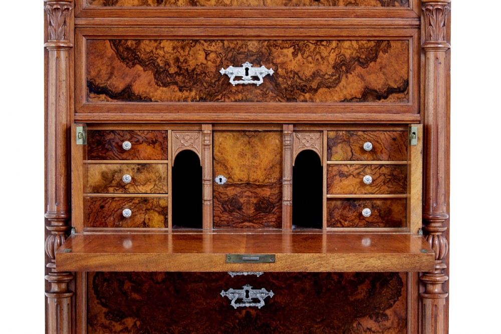 A tall 19th-century burr walnut secretaire chest of drawers featuring bookmatched veneer drawer fronts, fluted side columns, and ornate metal escutcheons. View XI
