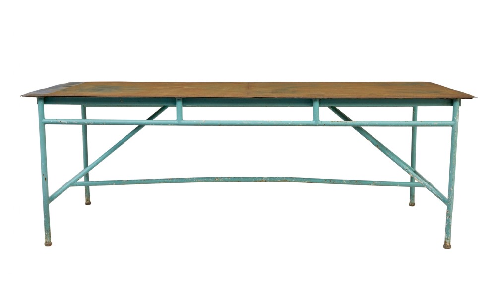 A large 1920s industrial table featuring a turquoise painted tubular steel frame with diagonal bracing and a flat rusty steel top. View II