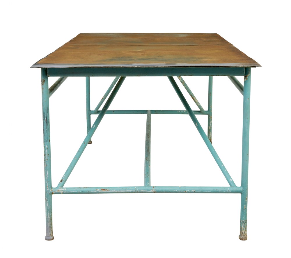 A large 1920s industrial table featuring a turquoise painted tubular steel frame with diagonal bracing and a flat rusty steel top. View III