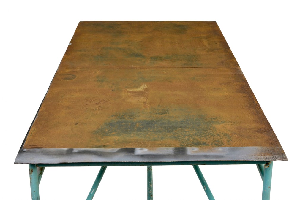 A large 1920s industrial table featuring a turquoise painted tubular steel frame with diagonal bracing and a flat rusty steel top. View VII