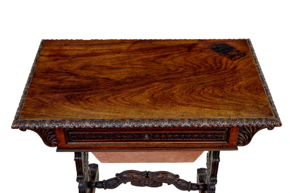 A 19th-century dark carved padouk wood side table featuring an integrated fabric work well and carved trestle legs. View II
