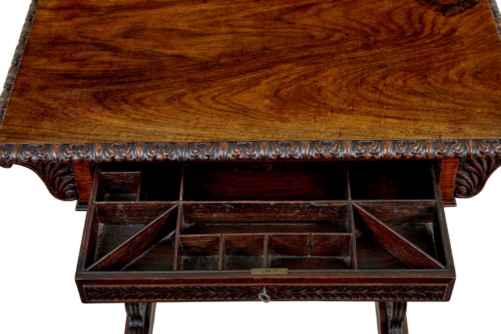 A 19th-century dark carved padouk wood side table featuring an integrated fabric work well and carved trestle legs. View III