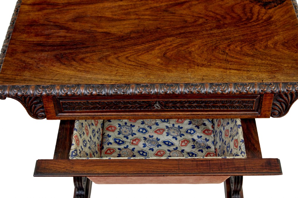 A 19th-century dark carved padouk wood side table featuring an integrated fabric work well and carved trestle legs. View IV