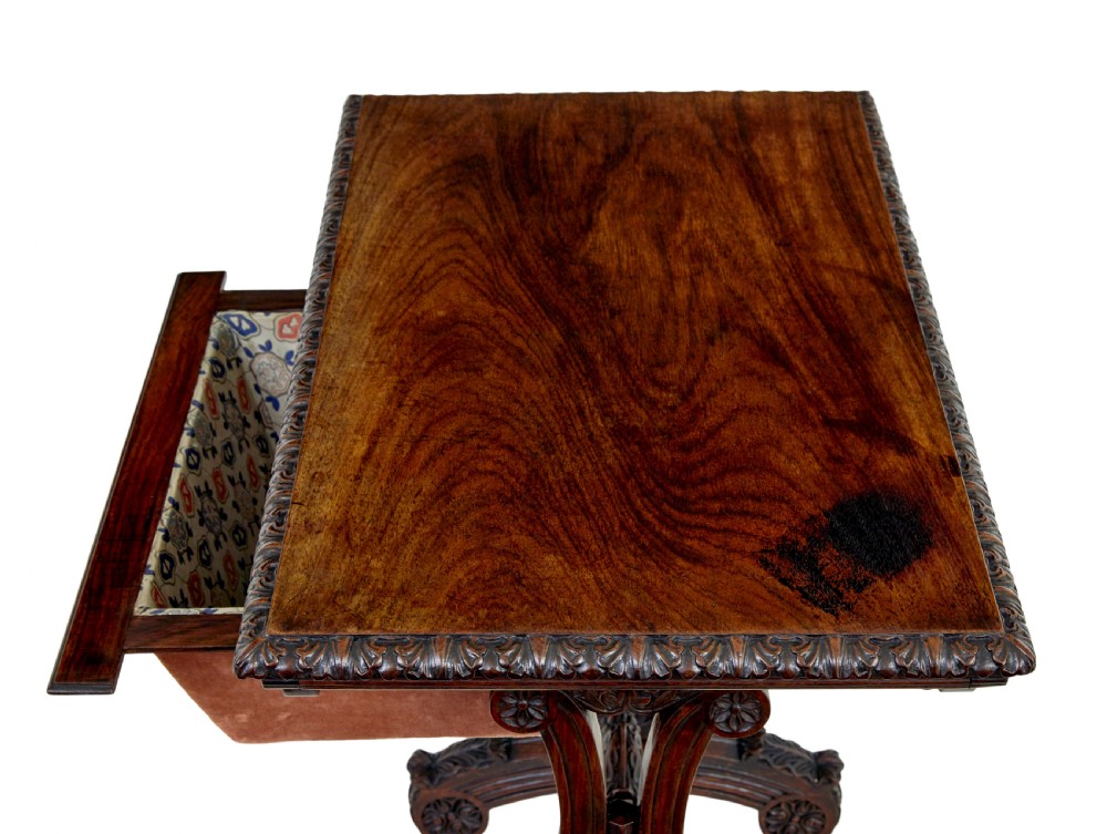 A 19th-century dark carved padouk wood side table featuring an integrated fabric work well and carved trestle legs. View V