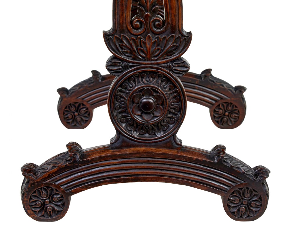 A 19th-century dark carved padouk wood side table featuring an integrated fabric work well and carved trestle legs. View VI