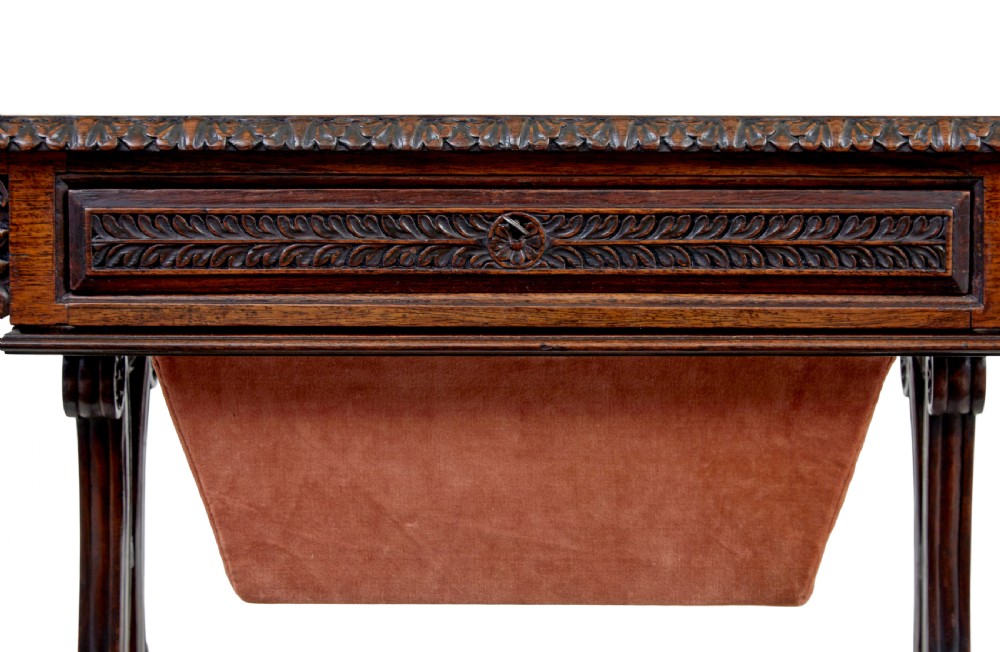 A 19th-century dark carved padouk wood side table featuring an integrated fabric work well and carved trestle legs. View VII