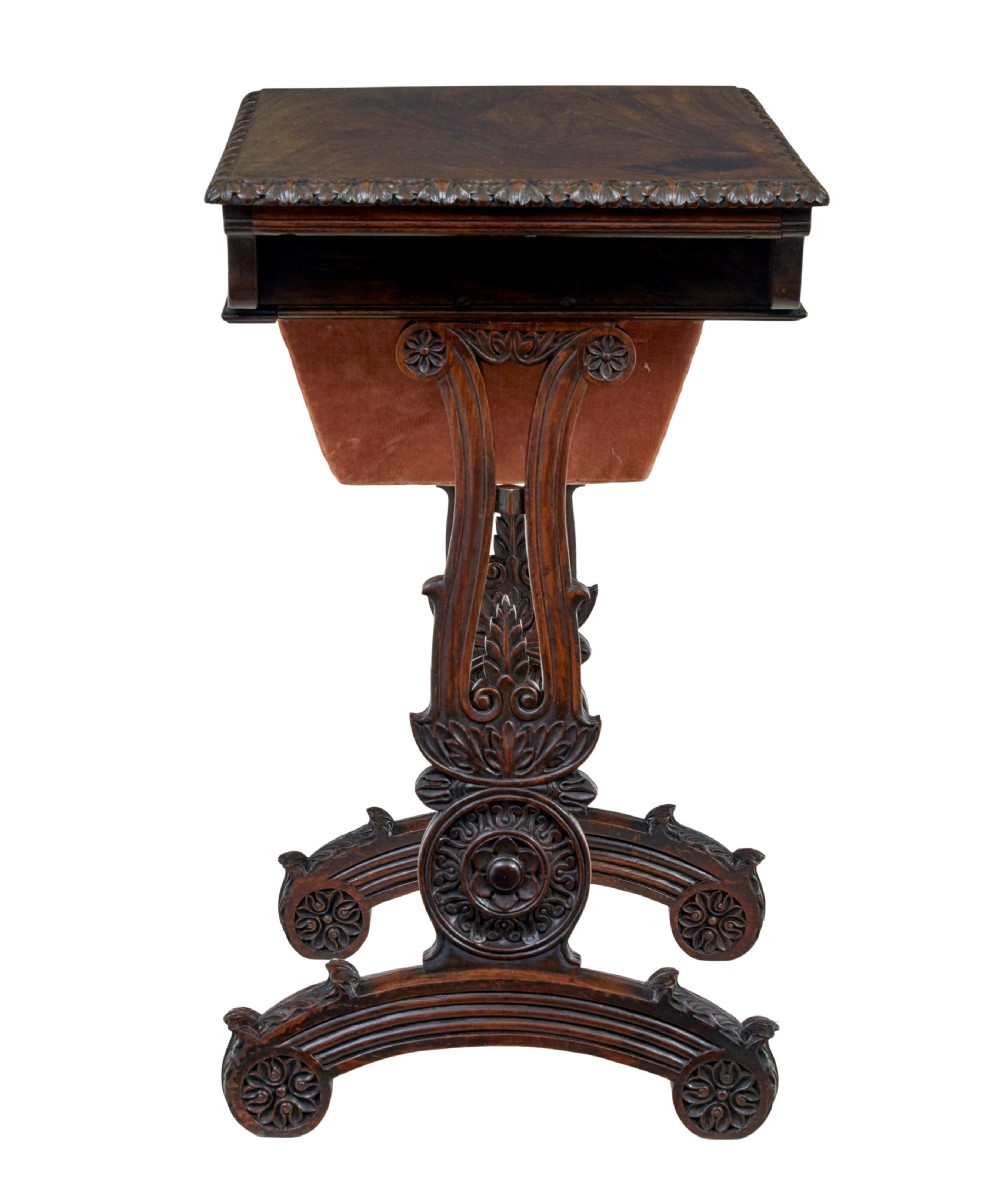 A 19th-century dark carved padouk wood side table featuring an integrated fabric work well and carved trestle legs. View IX