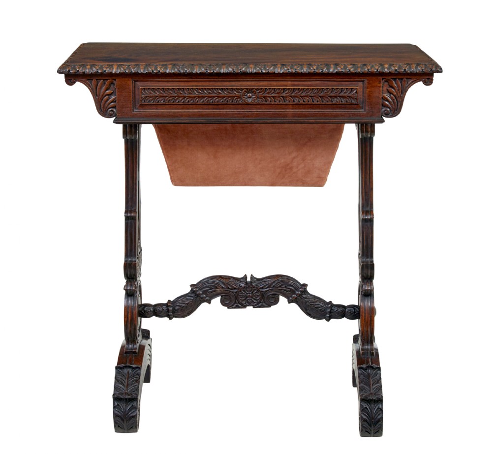 A 19th-century dark carved padouk wood side table featuring an integrated fabric work well and carved trestle legs. View X