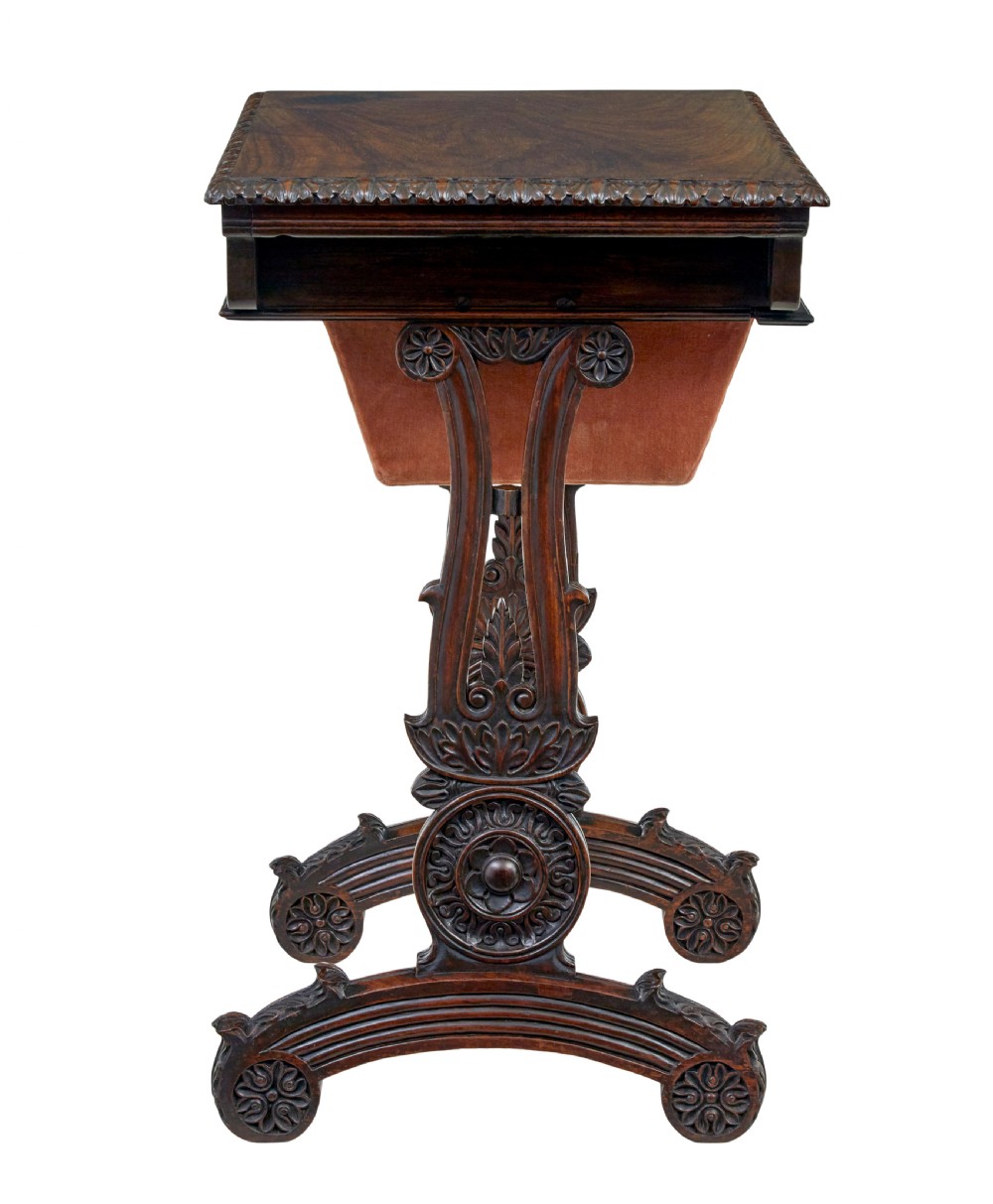 A 19th-century dark carved padouk wood side table featuring an integrated fabric work well and carved trestle legs. View XI
