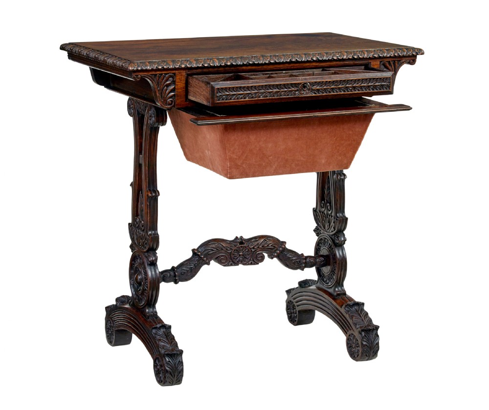 A 19th-century dark carved padouk wood side table featuring an integrated fabric work well and carved trestle legs. View XII