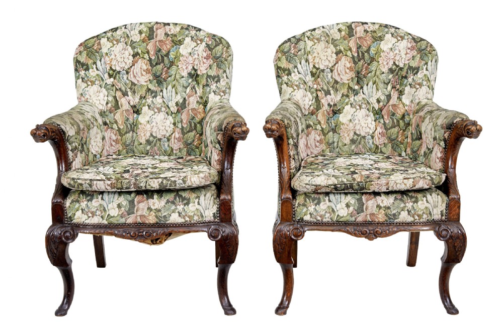 A pair of 19th-century French carved oak armchairs upholstered in a green floral tapestry fabric with carved lion-head armrests. View II