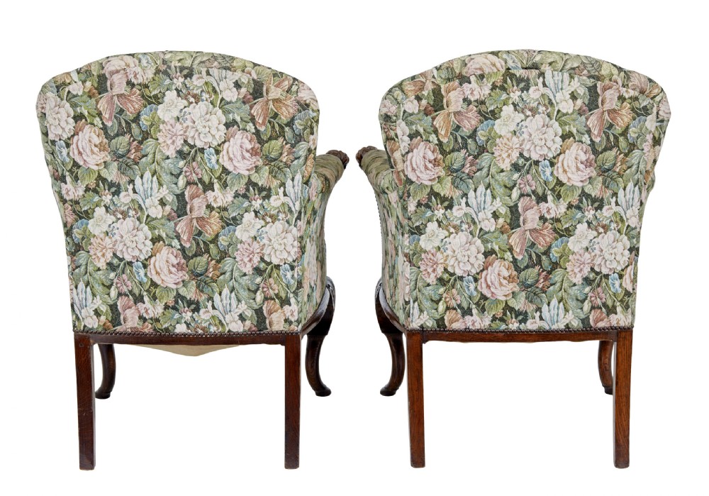 A pair of 19th-century French carved oak armchairs upholstered in a green floral tapestry fabric with carved lion-head armrests. View IV