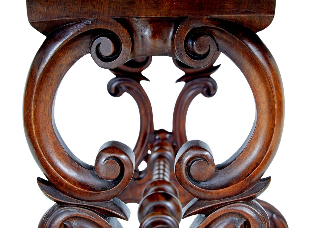 An oval 19th-century Victorian side table crafted from figured burr walnut with carved scroll legs, turned central stretcher, and ceramic castors. View VI