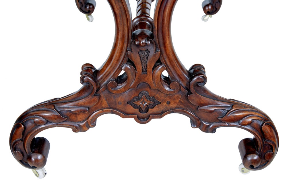 An oval 19th-century Victorian side table crafted from figured burr walnut with carved scroll legs, turned central stretcher, and ceramic castors. View VII