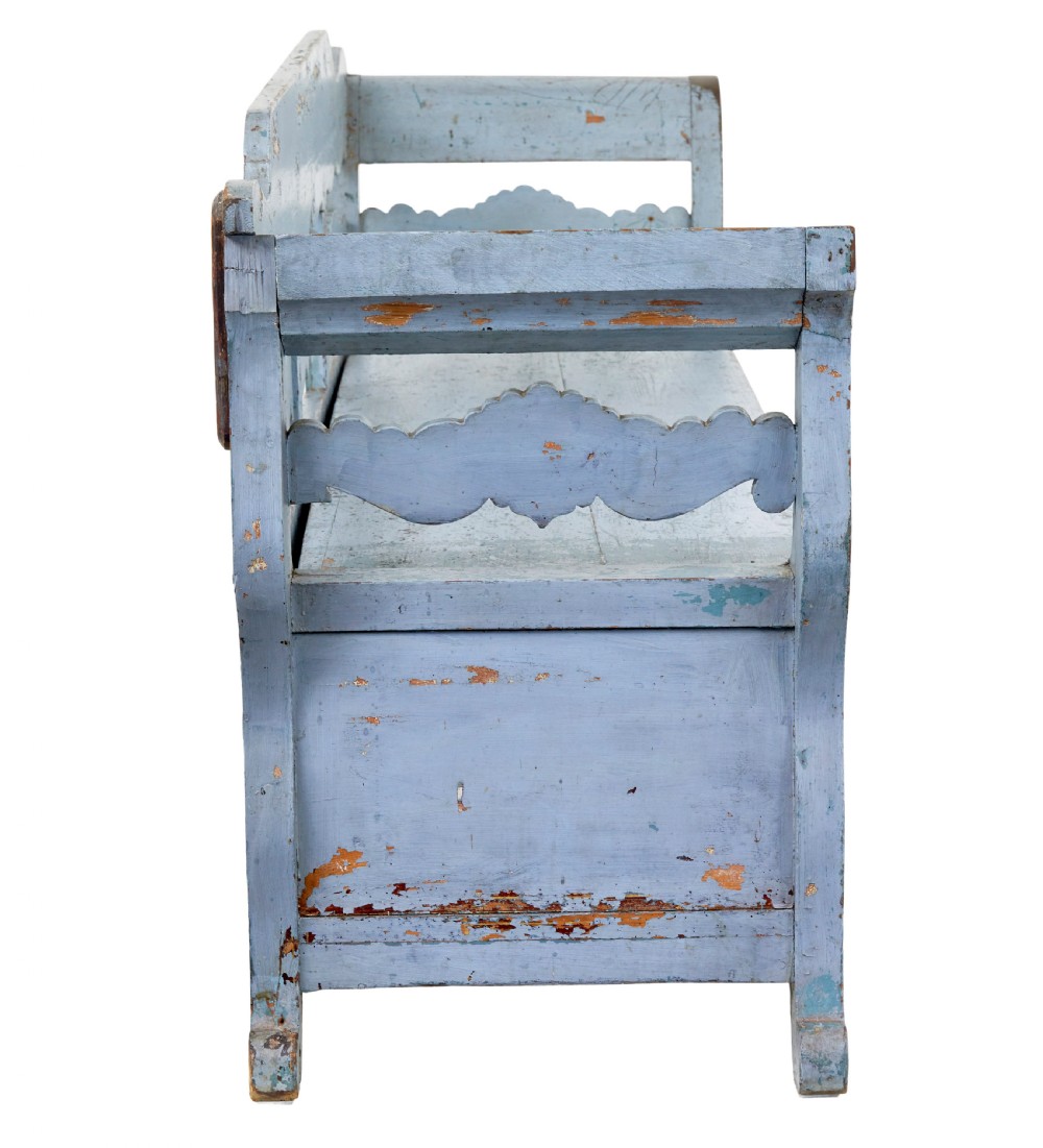 A mid 19th-century Swedish wooden storage bench featuring a distressed light blue painted finish, scalloped backrest rails, and flared armrests. View VII