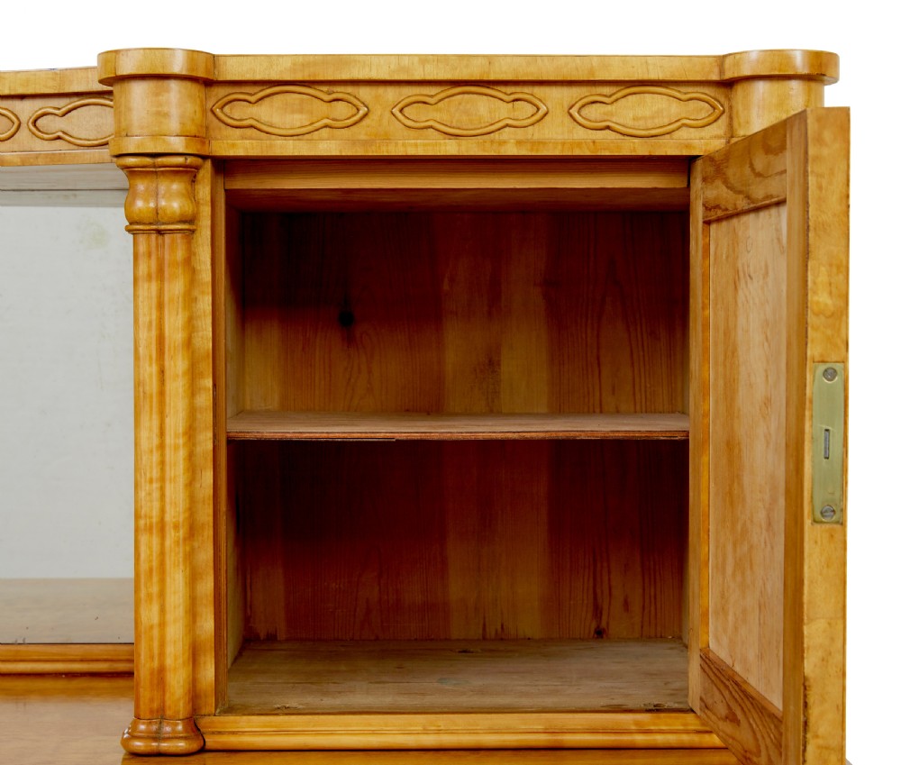 A mid-19th-century Swedish satin birch buffet sideboard featuring a lower three-door cabinet with carved petal applied mouldings and an upper tiered superstructure with Gothic arch cabinet doors. View X
