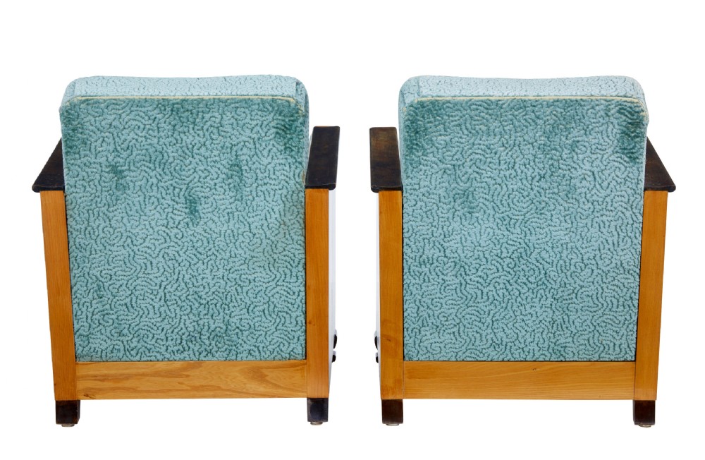 A pair of Swedish Art Deco armchairs featuring curved blonde wood arms, teal textured fabric upholstery, and dark block feet. View VI