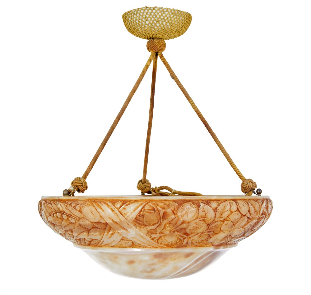 A carved warm amber alabaster ceiling bowl light suspended by three woven cords with a textured canopy.
