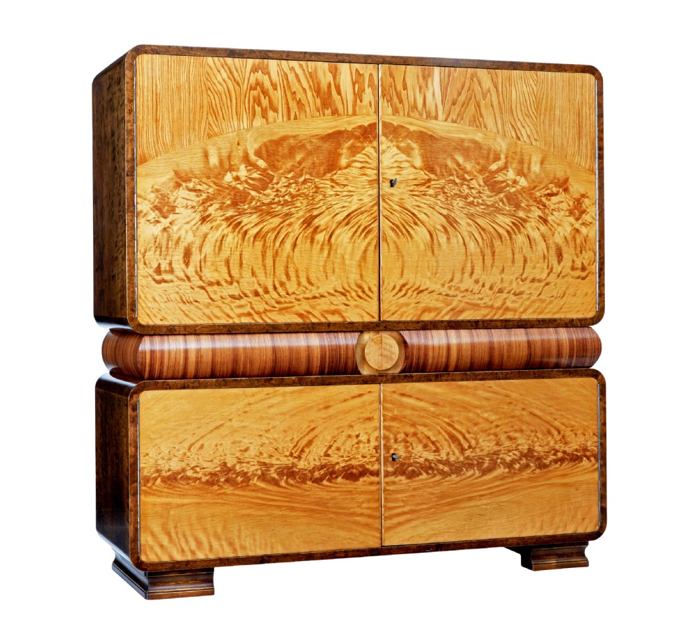 A Scandinavian Art Deco cabinet in blonde birch and elm veneer with two upper doors, a central reeded waist band, and two lower doors.