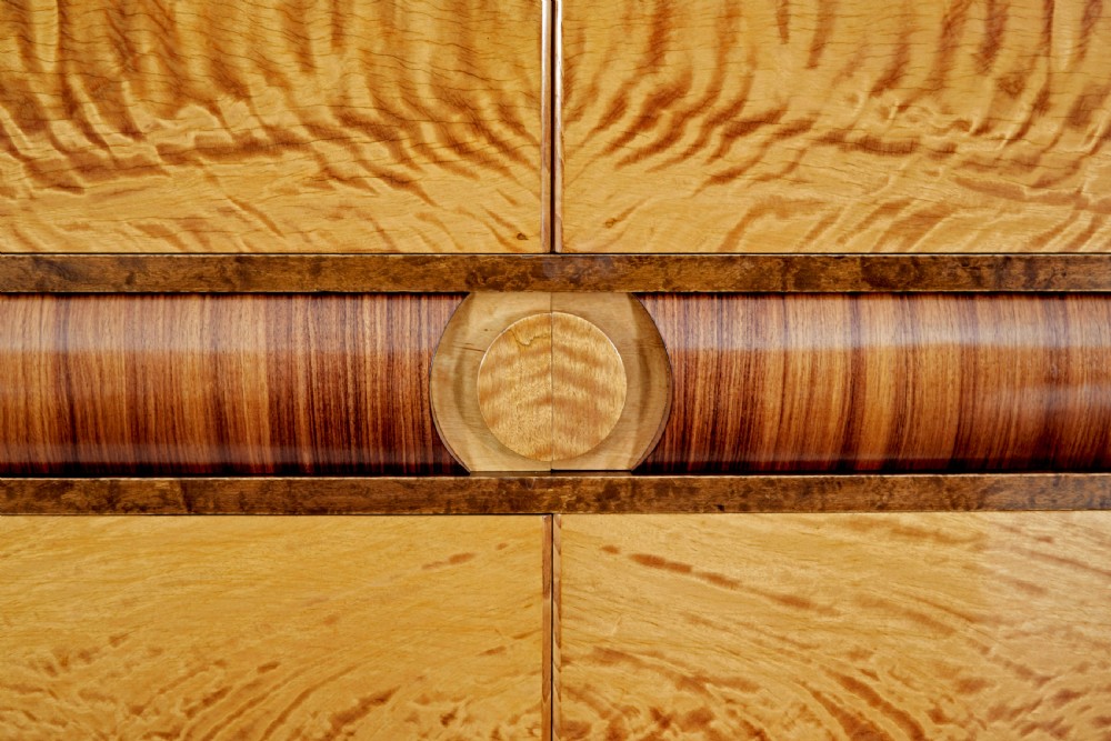 A Scandinavian Art Deco cabinet in blonde birch and elm veneer with two upper doors, a central reeded waist band, and two lower doors. View VIII