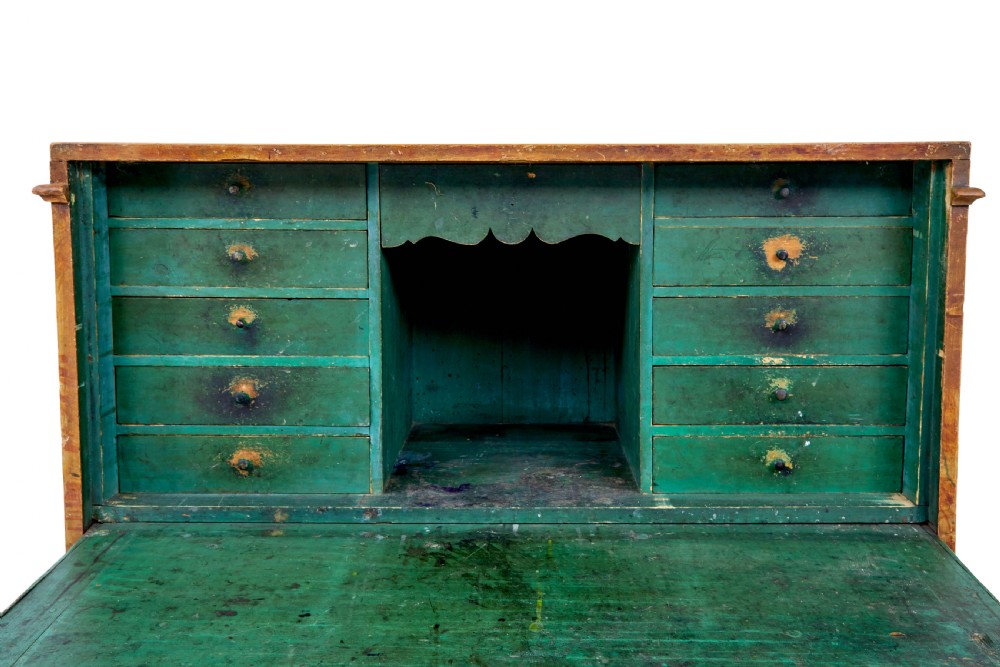 A 19th-century Swedish painted pine escritoire featuring a fall-front top section above three long drawers, finished in a faux-wood grain paint with brass drop handles and a scalloped plinth base. View IX
