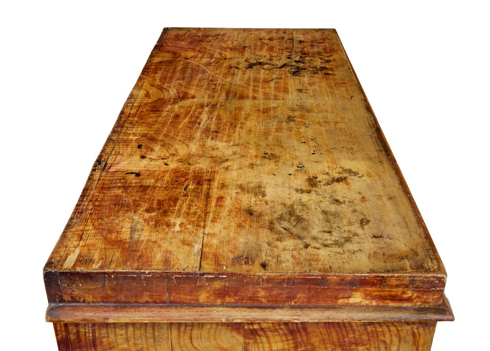A 19th-century Swedish painted pine escritoire featuring a fall-front top section above three long drawers, finished in a faux-wood grain paint with brass drop handles and a scalloped plinth base. View XII