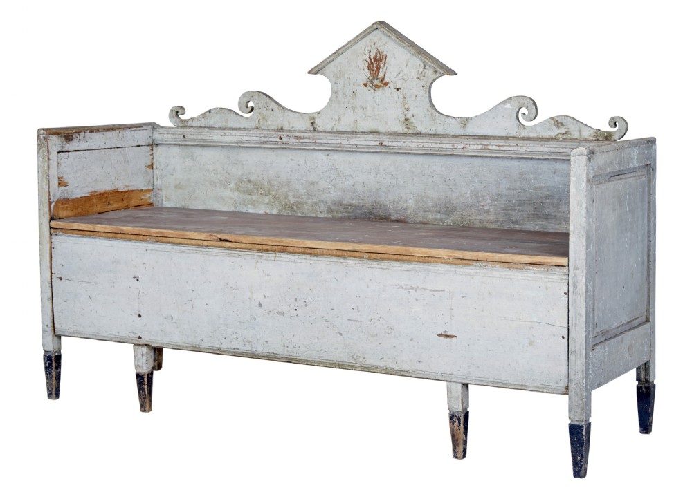 An early 19th-century Swedish Gustavian bench in distressed grey paint featuring a pedimented backrest and tapered legs.