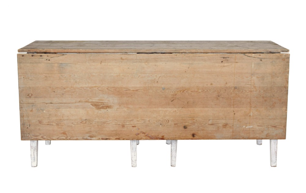 A 19th-century pine drop-leaf kitchen table featuring a natural wood top, hinged side flaps, end drawer, and a white-painted base with tapered square legs. View II