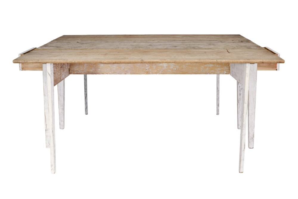 A 19th-century pine drop-leaf kitchen table featuring a natural wood top, hinged side flaps, end drawer, and a white-painted base with tapered square legs. View VI