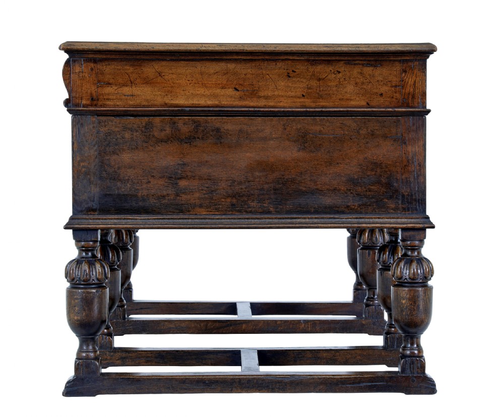 A late nineteenth-century Victorian dark carved oak pedestal desk featuring a leather writing surface, multiple drawers, and turned legs on stretcher bases. View VII